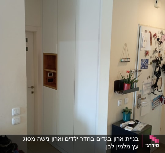 ארון לבן עם דלתות סגורות ומדף עץ קטן